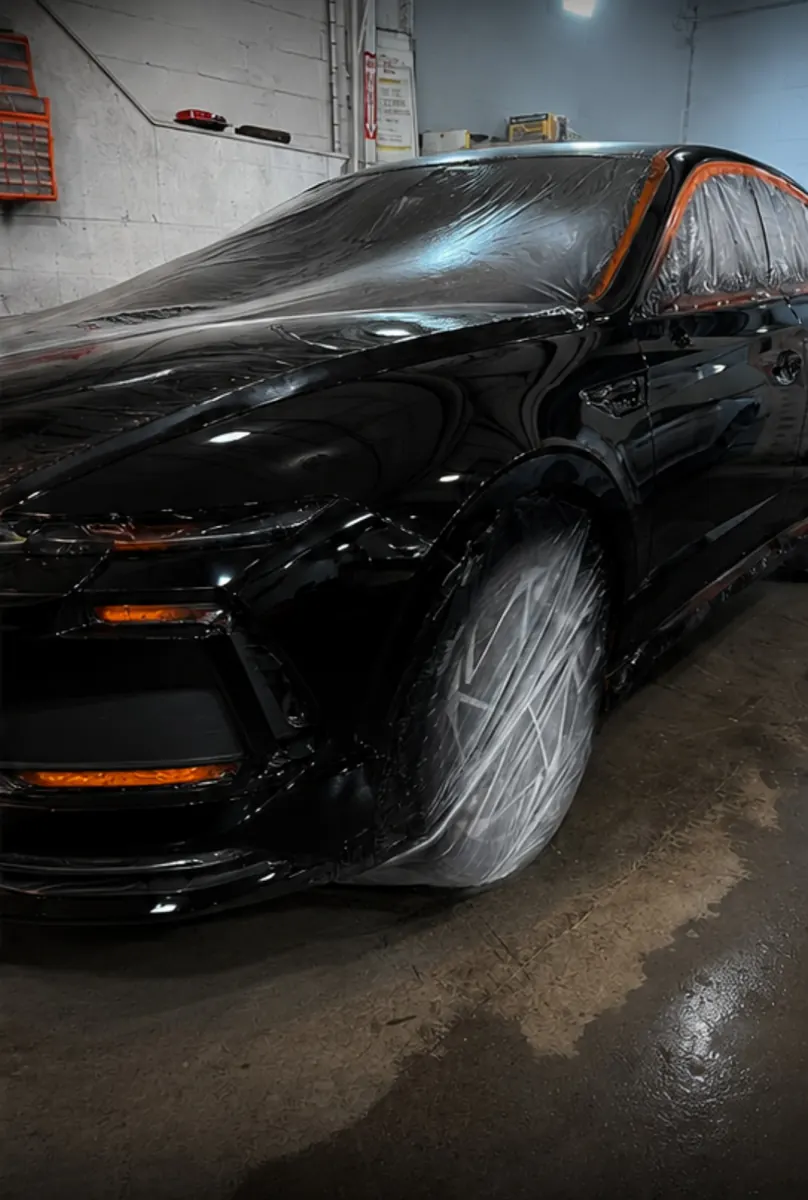 The same black sedan with the front end freshly painted