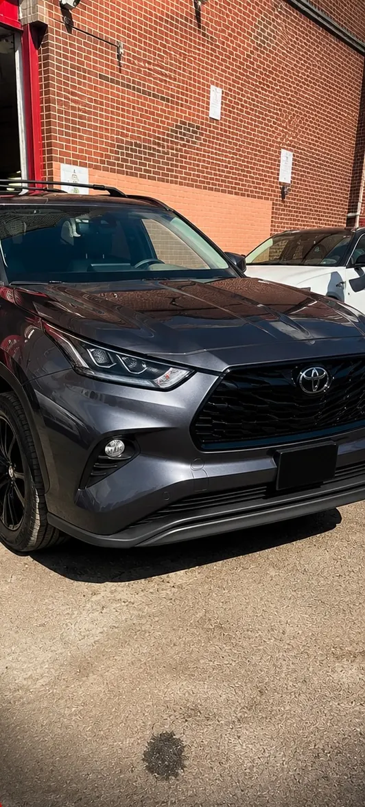 Dark grey Toyota Highlander parked outside the shop