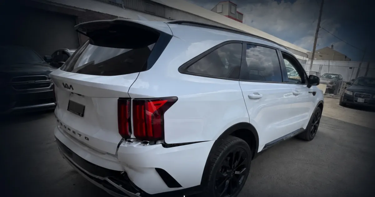 White Kia Sorento with a damaged rear bumper