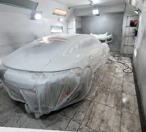 Car masked in plastic inside the RM paint booth